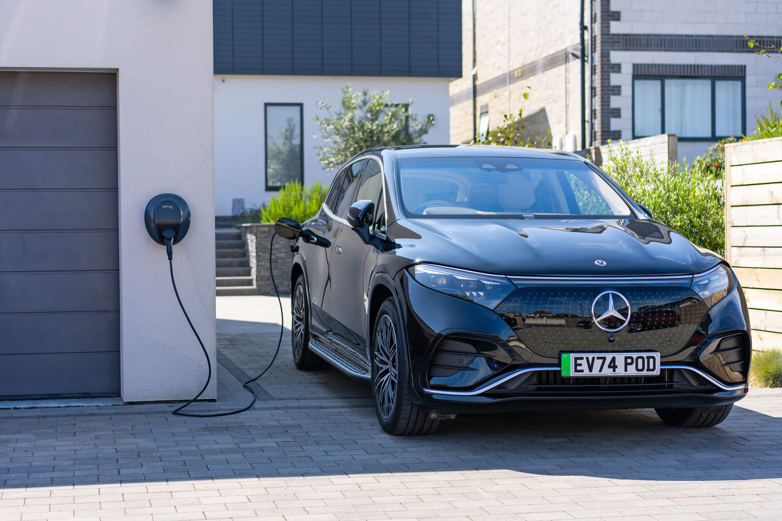 Electric vehicle plugged into a Pod Point home charger for convenient overnight charging.