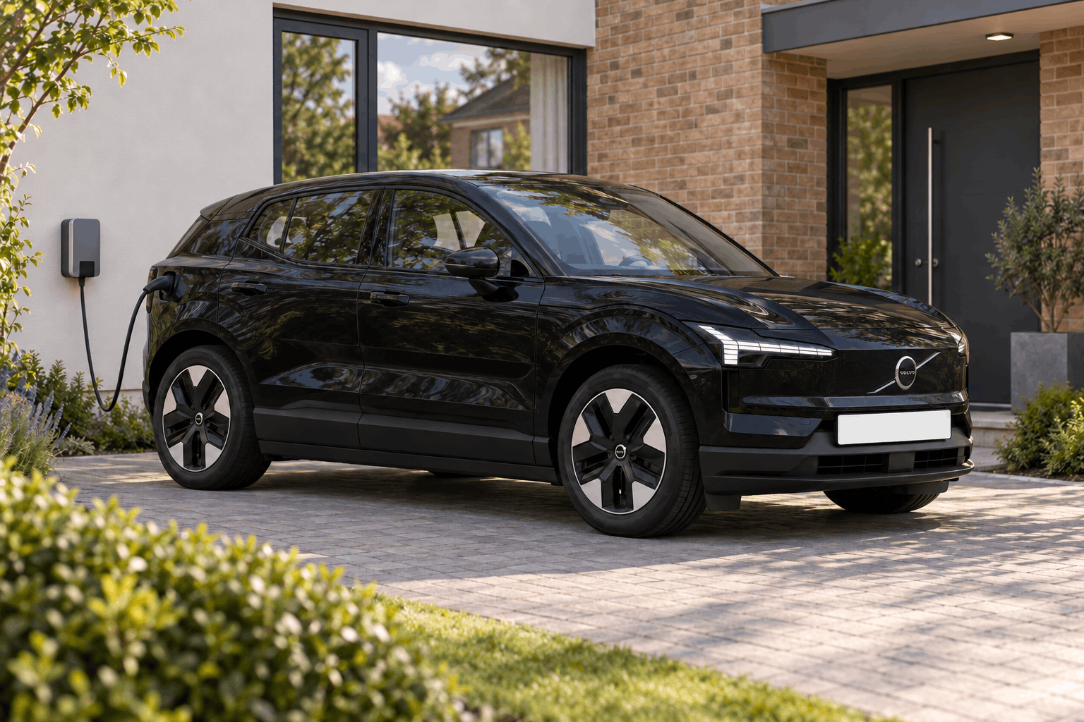 Onyx Black Volvo EX30 charging outside a contemporary home.